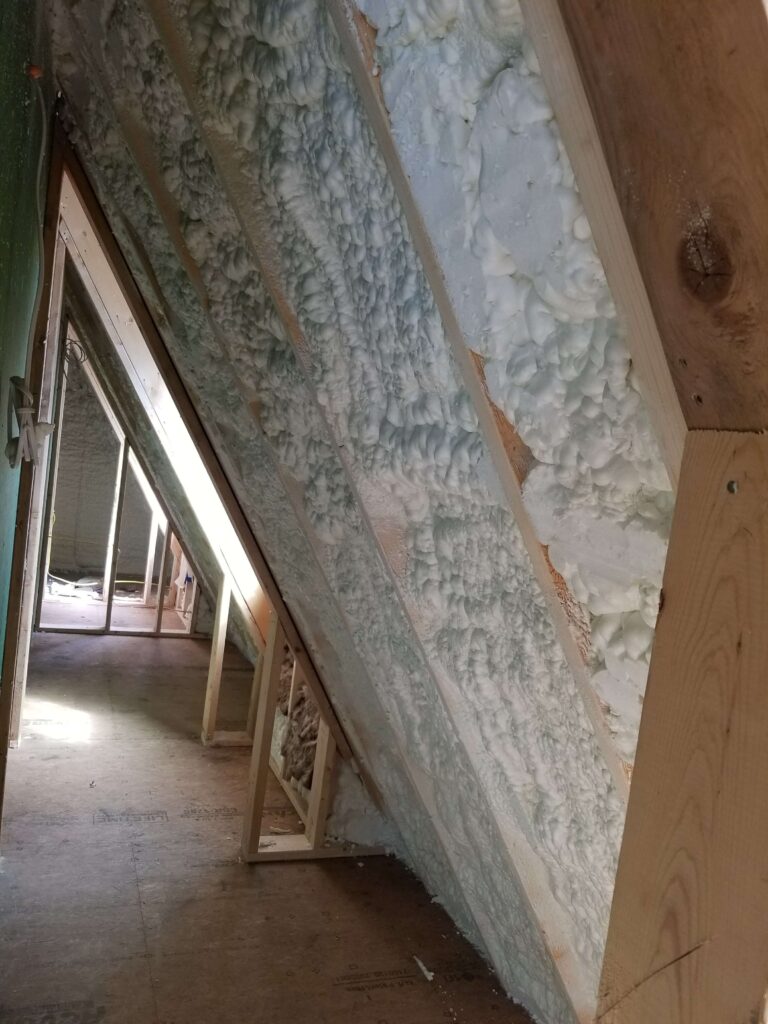 spray foam insulation in the walls of an attic