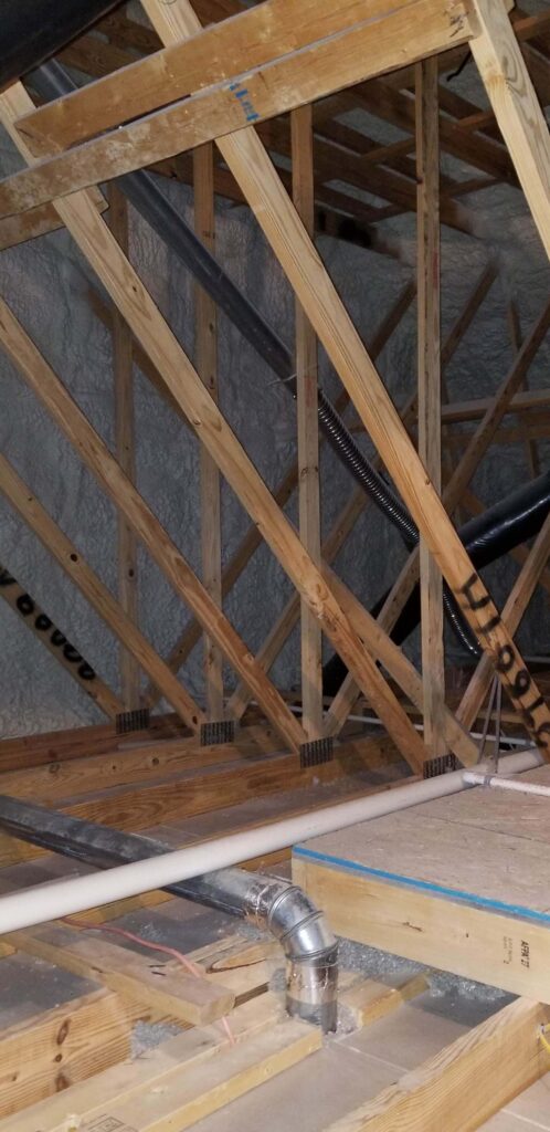 spray foam insulation being installed in residential attic framing