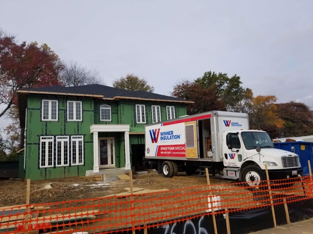 Residential home under construction with Winner Insulation truck outside