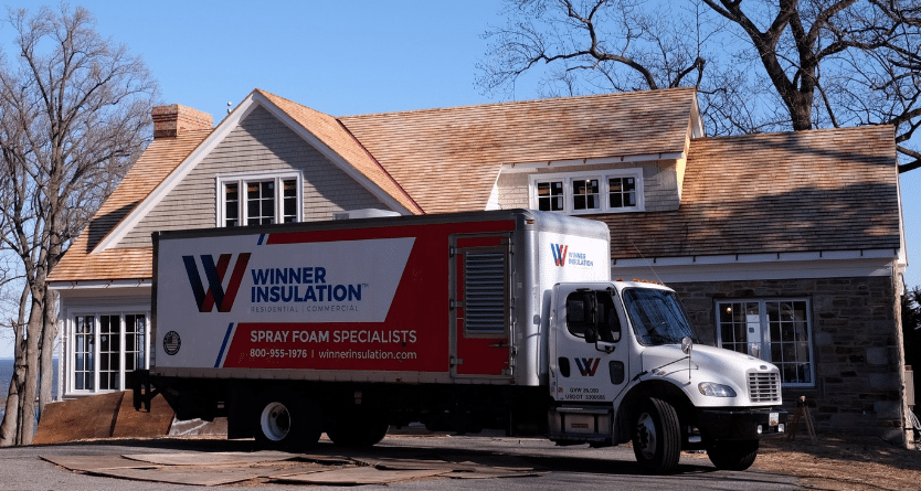 Winner Insulation truck parked outside of large home